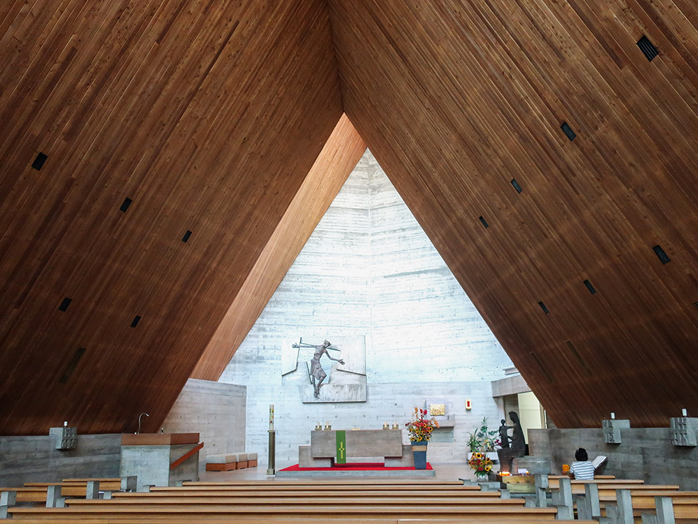Die Reduktion auf wenige Materialien wie Beton und Lärchenholz kennzeichnet das Innere der Kirche. Das zurückversetzte und erhöhte Dach des Chors erlaubt den gebündelten Lichteinfall in den Altarraum. (Bild: zVg)
