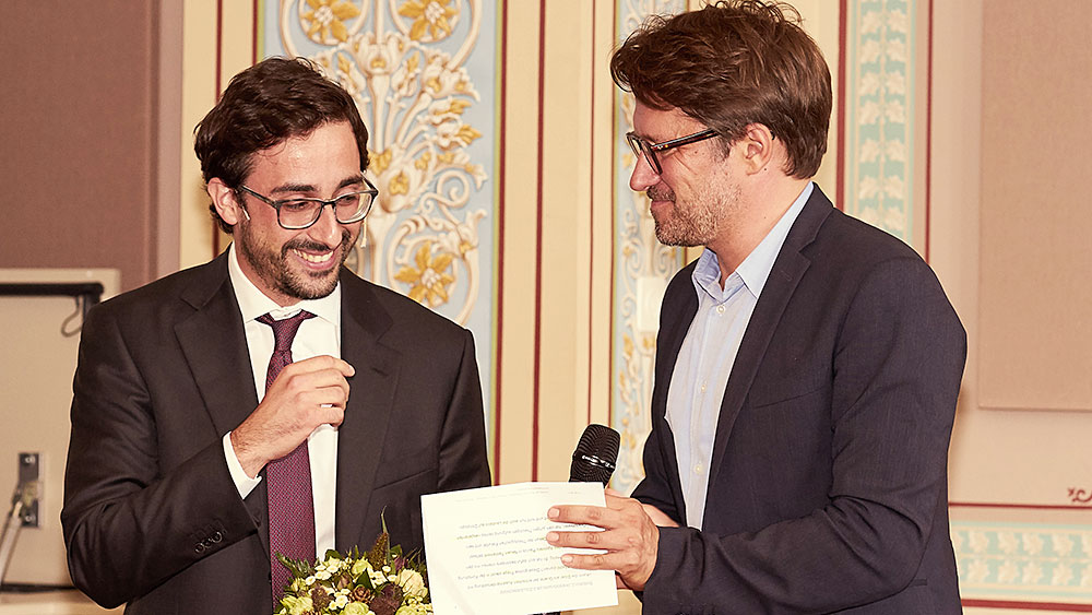 Economist Bruno Caprettini (left) investigated structural change in economics and processes of industrialization, in particular. Here he is pictured receiving the Mercator Award from Andrew Holland, Executive Director of the Mercator Foundation. (Picture: Laura Herrera)