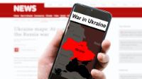 Handy mit News vor Website mit News zu Ukraine-Krieg
