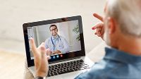 Älterer Patient kommuniziert mit Arzt via Tablet