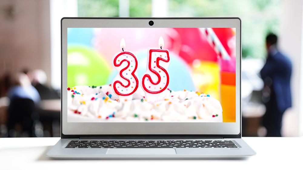 Computer mit Geburtstagstorte