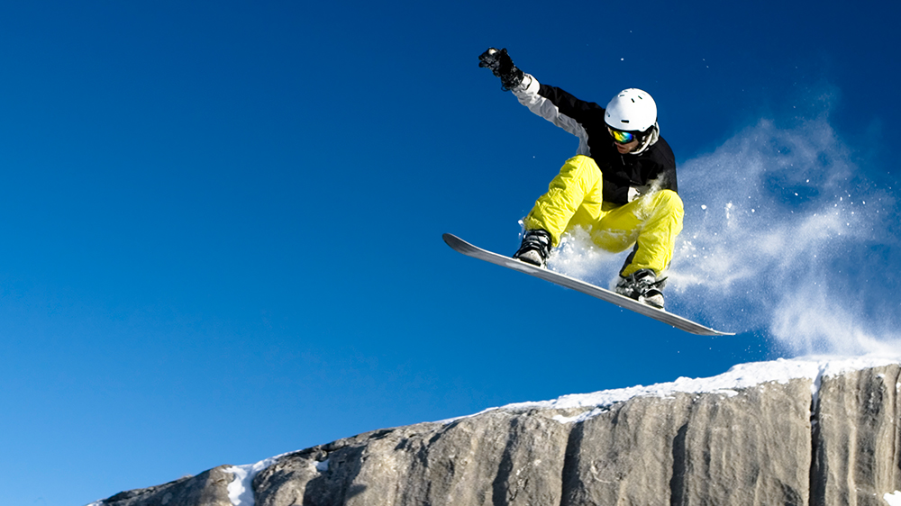 Snowboarder über einer Felswand