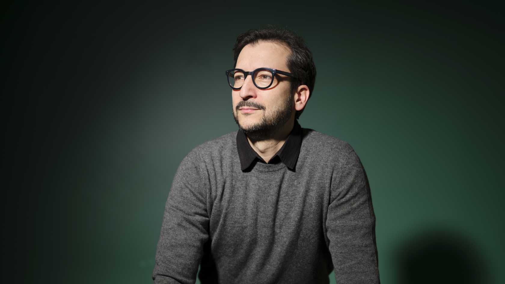 Portraitbild von Ataman Sendoel vor grünem Hintergrund.