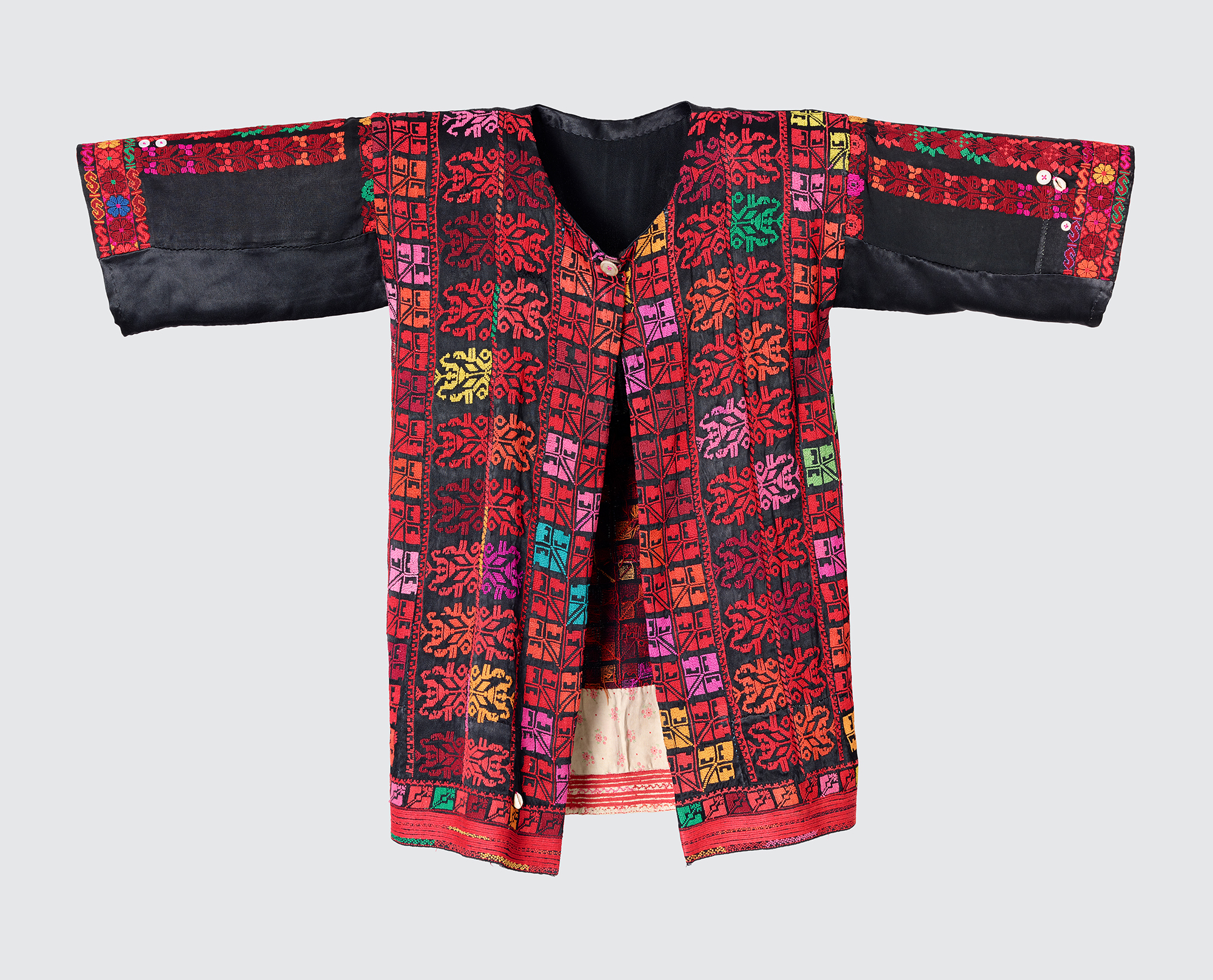 Jacket for a married woman with embroidery in shades of red, the color of fertility and sexuality, made of a fine cotton-silk blend. Collected by Widad Kamel Kawar in the Suf Refugee Camp (Jordan), 1996. Region of origin: Negev, 1950s.