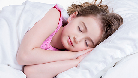 Das Bild zeigt ein schlafendes junges Mädchen im Bett.