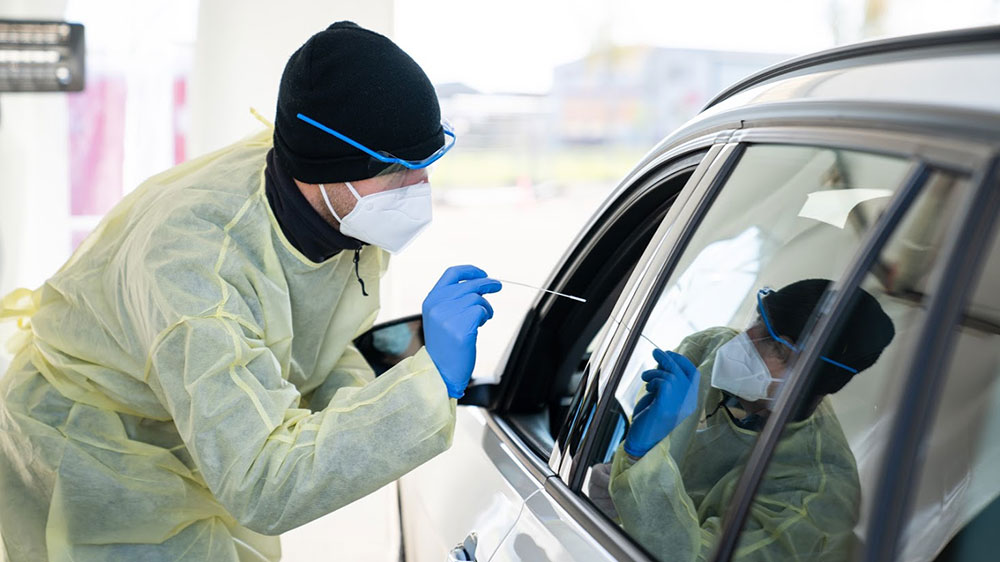 Ein UZH-Student nimmt den Nasen-Rachen-Abstrich vor. Für den Test müssen die Autofahrer das Fahrzeug nicht verlassen.