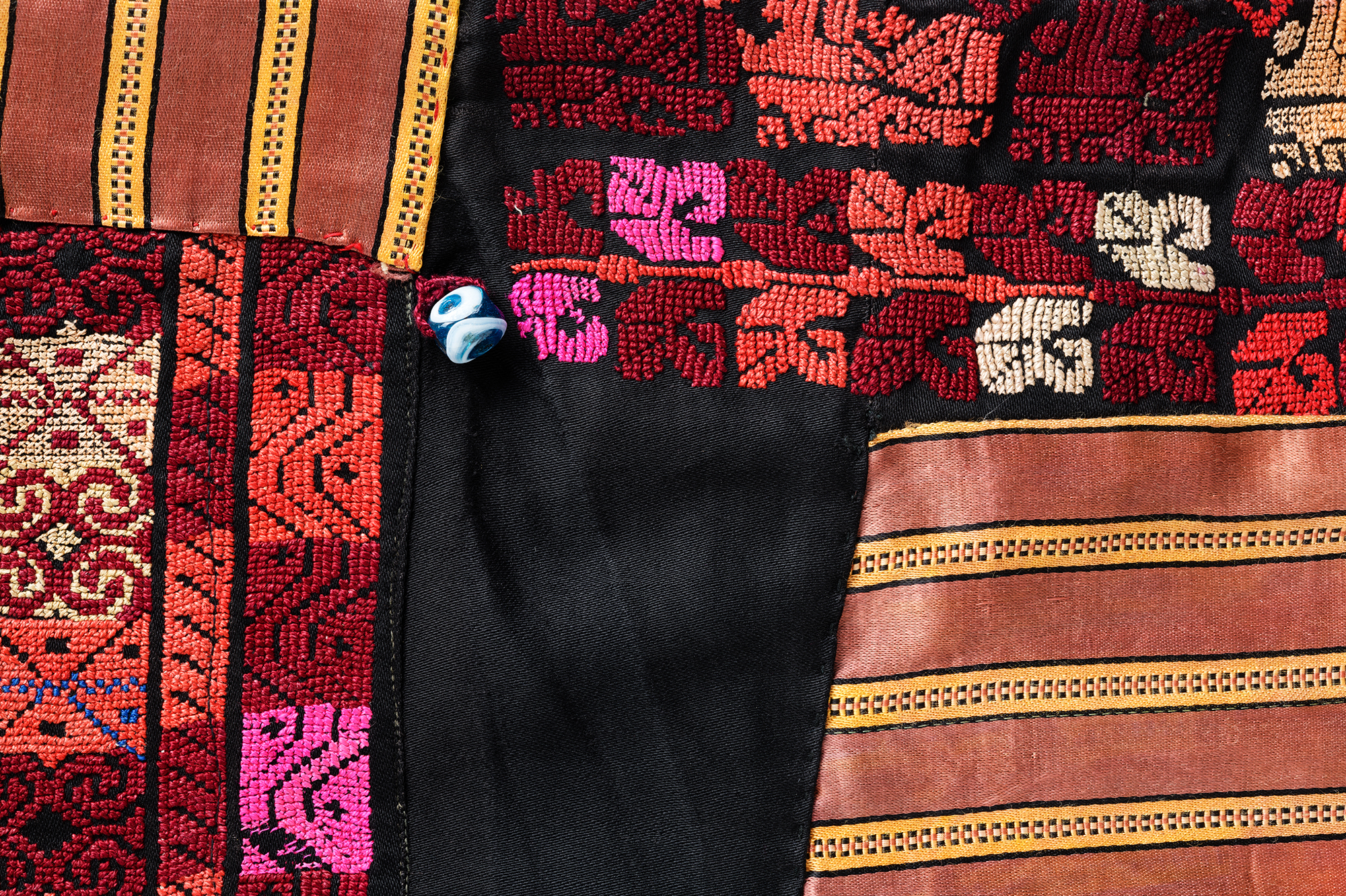 Amulets and beads protect against the evil eye and were often sewn onto Bedouin clothing. Close-up of the dress. Region of origin: Negev-North Sinai (border region with Egypt), ca. 1945.
