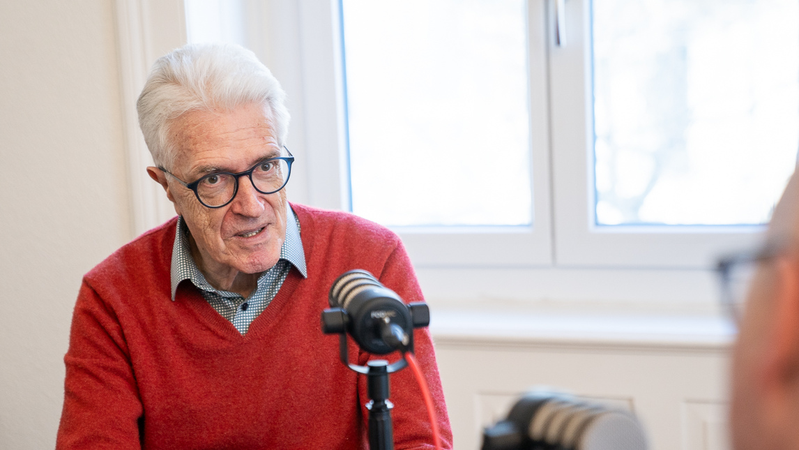 Werner van Gent in rotem Pullover vor Mikrofon