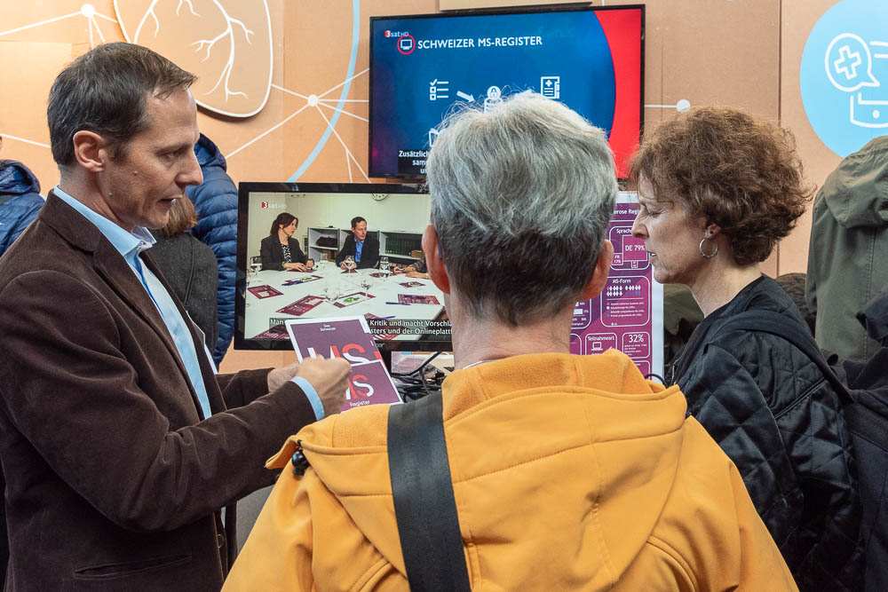 Viktor von Wyl stellt Besucherinnen des Digitaltags das Schweizer Multiple Sklerose Register der UZH vor.