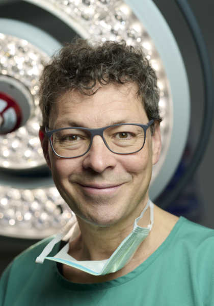 Portrait photo of José Oberholzer in surgical attire in front of an operating room light.
