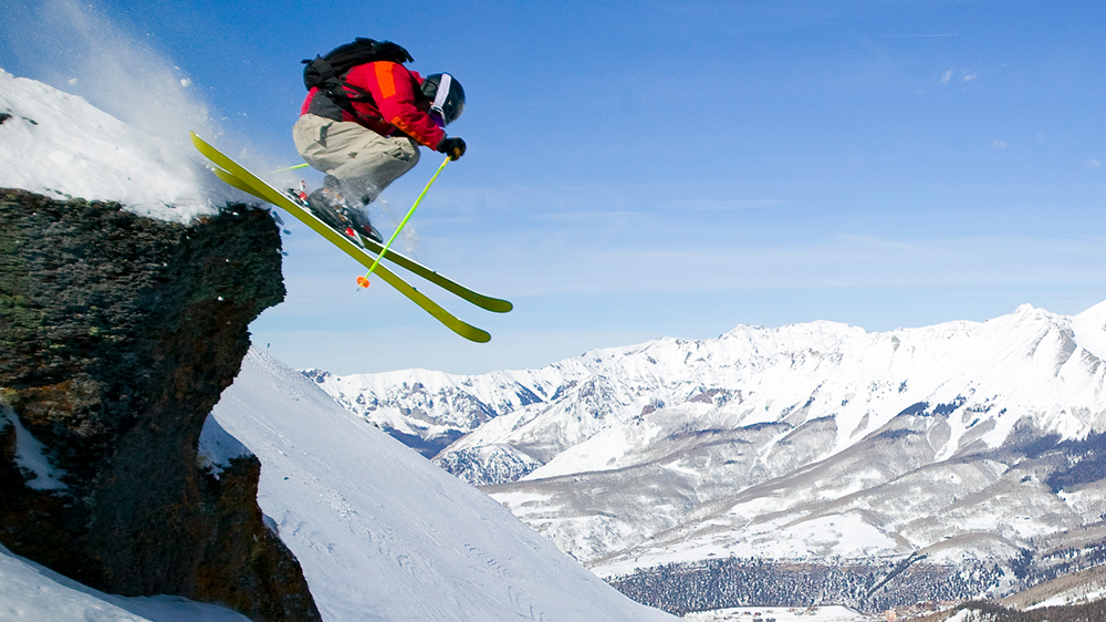 Skier jumping over a rock