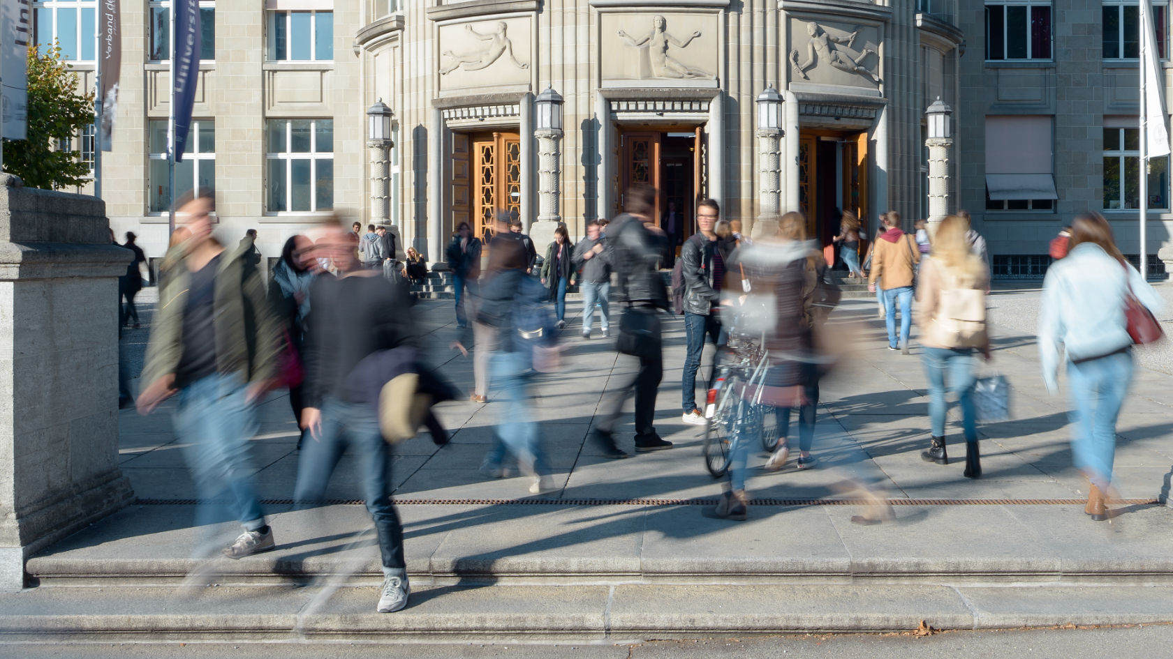 Verschwommen fotografierte Menschen vor dem Hauptgebäude der UZH