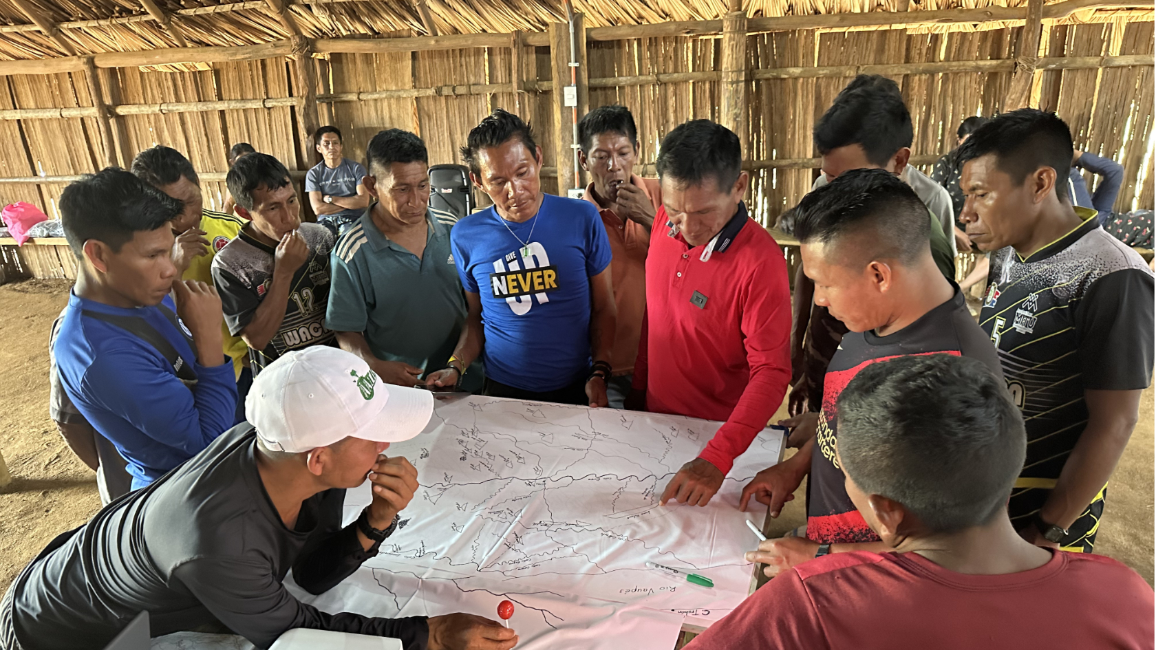 Members of the Cacua tribe with the researchers looking at the map showing where the new palm tree can be found.